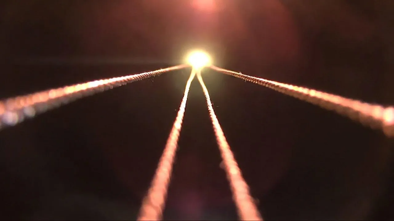 Quatre fils de cuivre convergeant vers un point de lumière, les quatre étapes du parcours